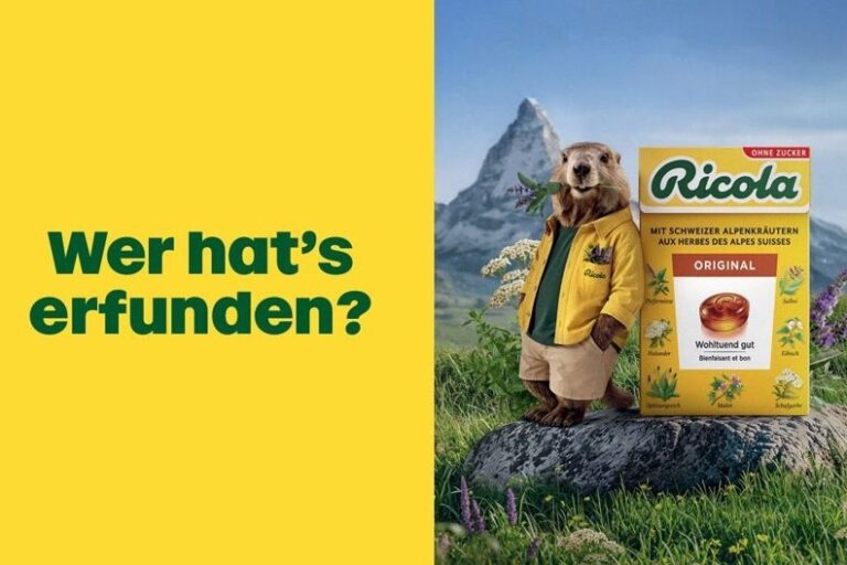 Kampagnenmotiv von Ricola: gelber Hintergrund mit dem Schriftzug „Wer hat’s erfunden?“, Murmeltier und Ricola-Packung vor Bergkulisse