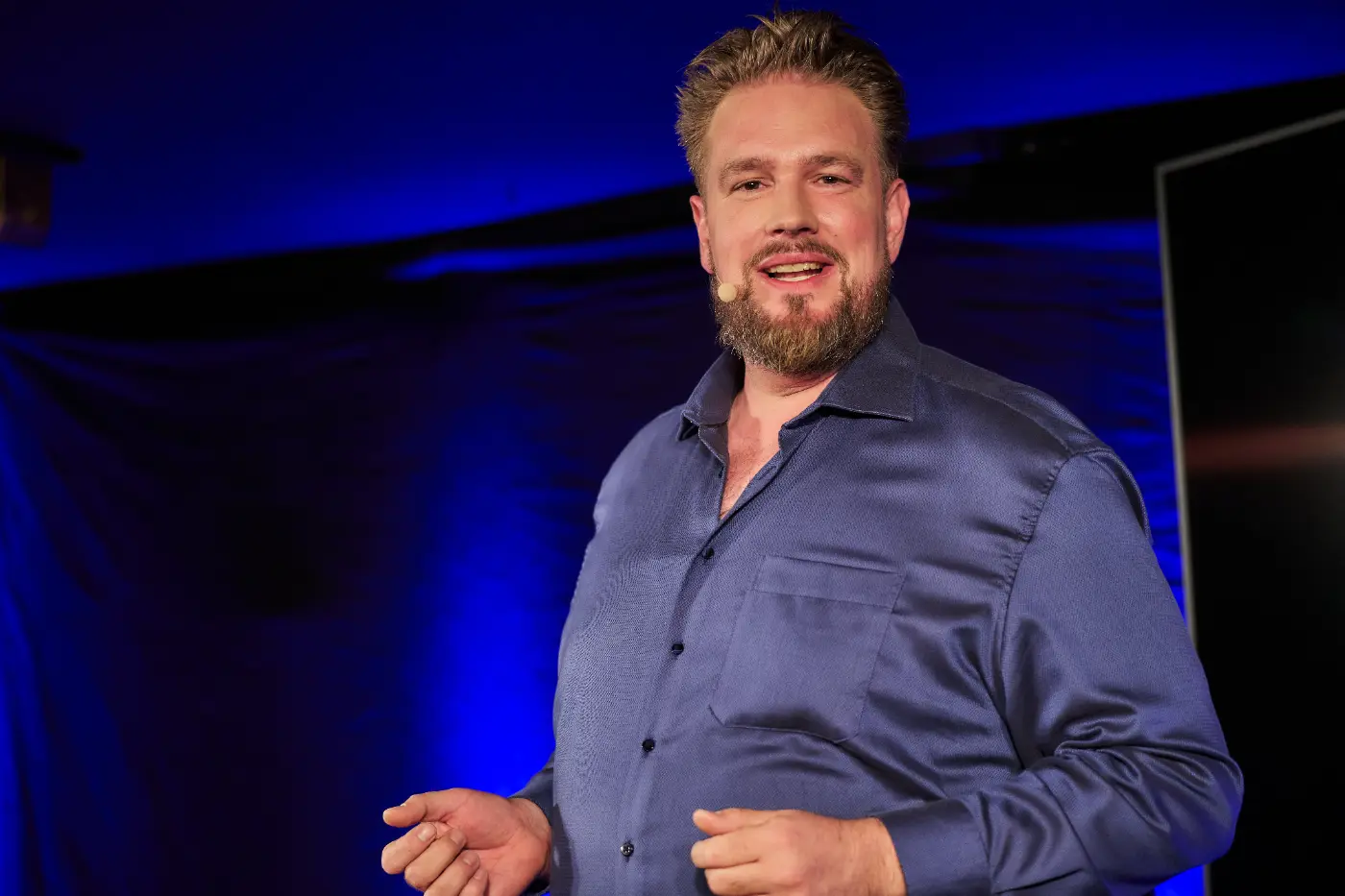 Keynote Speaker Thomas Daamen lächelnd mit offenen Händen auf der Iberl-Bühne